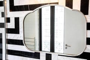 巴黎罗斯波本酒店的浴室设有镜子,墙上是黑白的