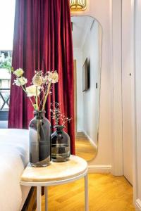巴黎罗斯波本酒店的一张桌子,上面有两瓶花,上面有镜子