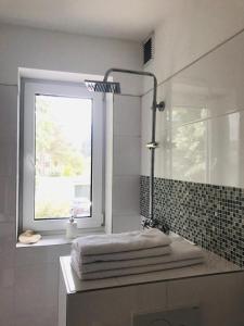 汉诺威Martins Guesthouse Zimmer的浴室设有窗户、水槽和毛巾