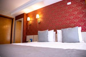 巴西利亚Cancún Hotel by H Hotéis - Airport的卧室配有白色的床铺和红色的墙壁