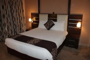 内罗毕机场着陆酒店的卧室配有一张带白色床单和枕头的大床。