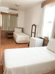 容迪亚伊Millian Hotel的一间卧室设有两张白色的床和窗户