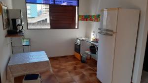 若昂佩索阿Regiane Beach Pousada Hostel的一间带冰箱和桌子的小厨房
