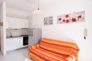 圣维托罗卡波Appartamento Sole的厨房配有冰箱和橙色毯子