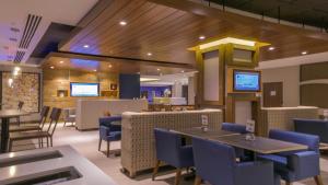 迈阿密迈阿密机场东套房智选假日酒店的一间设有蓝色桌椅和桌面的餐厅