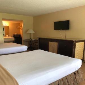 奥兰多Altamonte Springs Hotel and Suites的酒店客房设有两张床和一台平面电视。