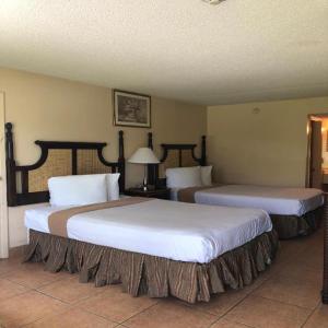 奥兰多Altamonte Springs Hotel and Suites的配有两张床的酒店客房中的两张床