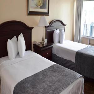 奥兰多Altamonte Springs Hotel and Suites的酒店客房设有两张床和窗户。