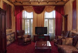 久姆里埃里桑德拉珀尔宫酒店的带沙发、电视和窗帘的客厅