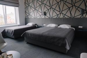特尔希艾Bohema的一间带两张床的卧室和几何墙