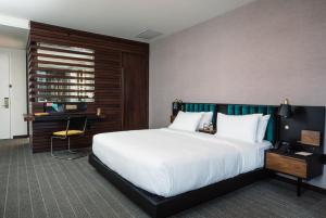 纳什维尔Fairlane Hotel Nashville, by Oliver的酒店客房带一张大床和一把椅子