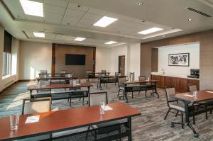 苏福尔斯Hyatt Place Sioux Falls South的一间会议室,配有桌椅和屏幕