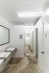 卢纳将军城Sunlit Hostel的白色的浴室设有两个盥洗盆和镜子