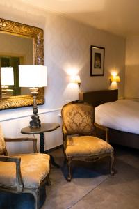 鲁汶博登那图尔住宿加早餐旅馆的一间卧室配有一张床、一把椅子和镜子