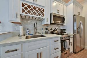 纽波特海滩1000#4 Modern Beach Home, Steps from Sand w/AC!的厨房配有白色橱柜、水槽和冰箱。
