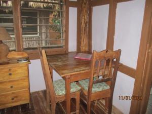 科罗萨尔Cerros Beach Inn的木制餐桌、两把椅子和书桌