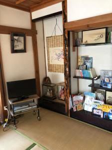 Mimase三井家ペットと泊れる一軒家らんまんで話題の牧野植物園まで25分的一间带电视和书架的客厅