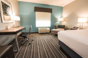 休斯顿Holiday Inn Express & Suites Houston - Hobby Airport Area, an IHG Hotel的酒店客房配有一张床、一张书桌和一台电脑