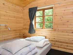 埃贝尔托夫特Peaceful Holiday Home in Jutland with Sauna的木制客房的一张床位,设有窗户