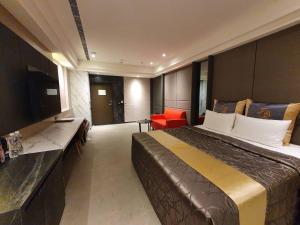 高雄日光高铁精品旅馆的酒店客房设有一张大床和一台电视。