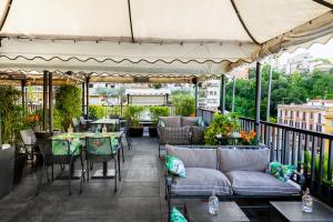 罗马特里卢萨宫温泉酒店及会议中心的庭院配有桌椅和桌椅。