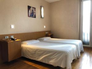 米兰欧洲酒店的卧室设有一张白色大床和一扇窗户。