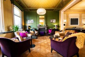 里提Villa Tilia的客厅配有紫色椅子和壁炉