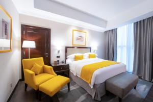 多哈多哈千禧国际酒店的酒店客房,配有床和黄色椅子