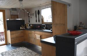 尚佩里L'Eglantine的厨房配有木制橱柜和黑色台面