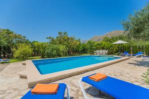 波连斯萨Casa de Campo con Encanto的一个带2把蓝色椅子和遮阳伞的游泳池