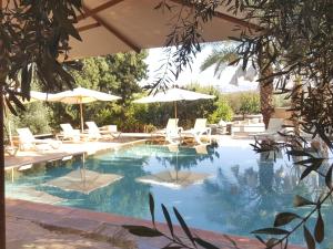 拉拉塔可库斯特珍内蒂希特住宿加早餐旅馆的一个带椅子和遮阳伞的游泳池