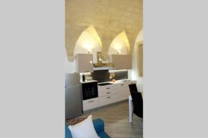 莱切Nel Cuore di Lecce的厨房配有白色橱柜和炉灶烤箱。
