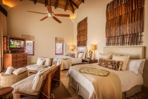 托拉Mukul Resort的一间卧室配有两张床和吊扇