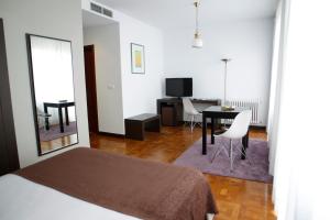 卢戈Hotel Mendez Nuñez的一间卧室配有一张床铺和一张桌子,还有一间用餐室