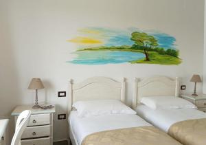 皮切尔诺Locanda Arcadia的一间卧室设有两张床,墙上挂着一幅画