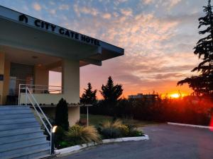 塞萨洛尼基City Gate Hotel Airport Thessaloniki的城市之门酒店,以日落为背景