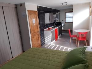 埃尔塔波Lodging Quirinal的一间带绿色床的卧室和一间厨房