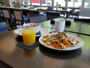 圣地亚哥圣地亚哥靛蓝酒店 - 格斯灯街区的一张桌子,上面放着两盘食物和一杯橙汁