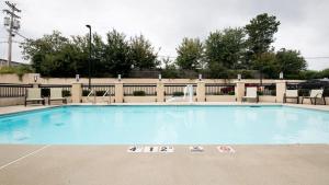 石头山亚特兰大斯通山快捷假日酒店的一个带椅子和围栏的大型游泳池