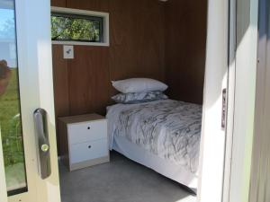 怀希Waihi Gold Alpacas 3 or 4 people的一个小房间的小床,设有窗户