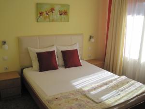 尼什Brankov Konak的一间卧室配有一张带红色枕头的大床