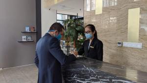 雅加达坦林雅加达自由酒店的两个人戴面具站在柜台
