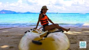 克雷登岛礁石度假酒店的一位妇女坐在海滩上的 ⁇ 萝上