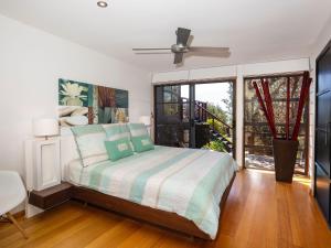 卡尔布拉海滩Illaroo Absolute Beachfront with Spa的一间卧室设有一张床和一个大窗户