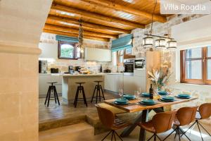 阿迪斯普普伦Atsipopoulo Villas的厨房以及带木桌和椅子的用餐室。