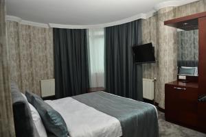 BostaniçiSARDUR HOTEL的酒店客房,配有床和电视