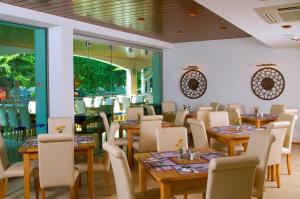 阿尔贝纳Flamingo Hotel 4*的餐厅设有木桌、椅子和窗户。