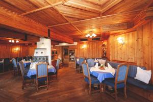 Sankt Lorenzen im MürztalRoanwirt的用餐室设有桌椅和木墙
