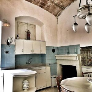 班约莱斯卡拉芙罗拉住宿加早餐旅馆的厨房配有白色橱柜、桌子和壁炉。