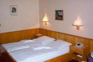 格奥尔格斯马林许特瓦德索赫酒店的卧室配有白色床、两盏灯和一部电话。